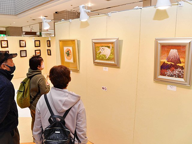 出品された作品をじっくりと鑑賞する来場者＝２５日午前１０時４２分、岐阜市正木中、マーサ２１