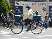 自転車に乗った人らが行き交うスクランブル交差点。４月から年齢にかかわらずヘルメットの着用が努力義務になる＝３０日午後１時４７分、岐阜市神田町