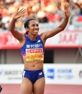 陸上の日本選手権女子１００メートルで連覇を果たし、スタンドに向かって笑顔で手を振る井戸アビゲイル風果＝１３日午後６時２６分、名古屋市瑞穂区、パロマ瑞穂スタジアム