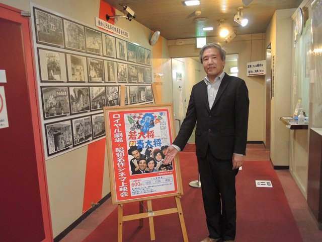 俳優田中邦衛さんを追悼して上映する「若大将対青大将」のポスターを前にする大野信浩総支配人＝岐阜市日ノ出町、ロイヤル劇場
