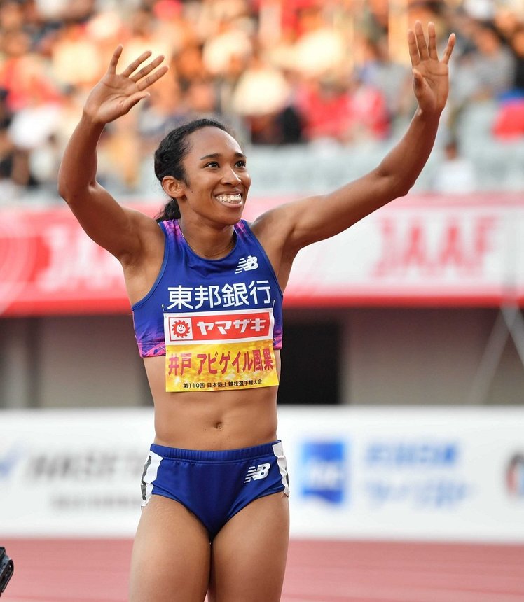 陸上の日本選手権女子１００メートルで連覇を果たし、スタンドに向かって笑顔で手を振る井戸アビゲイル風果＝１３日午後６時２６分、名古屋市瑞穂区、パロマ瑞穂スタジアム