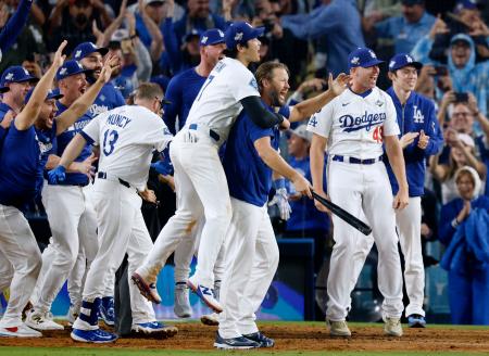 　米大リーグ、ブルージェイズとのワールドシリーズ第３戦の１８回、サヨナラ本塁打を放ったフリーマンを迎えるため本塁で待ち構えるドジャースの選手たち。右端は佐々木朗希、中央左は大谷翔平＝２７日、ロサンゼルス（共同）