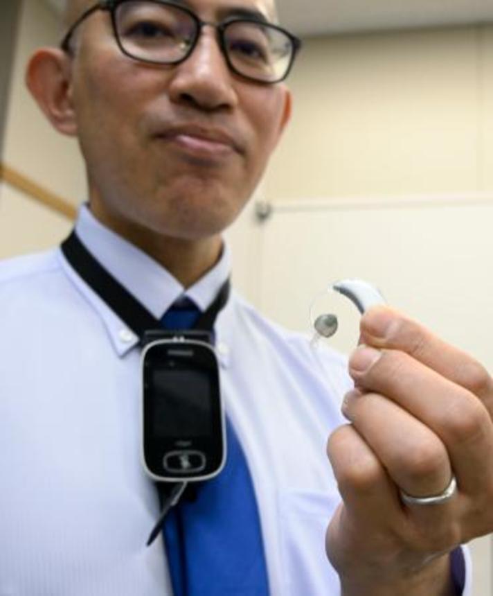 　「聞き取り困難症」の補助具のイヤホンとマイク。マイクは話し手の首にかけてもらう＝５月、堺市