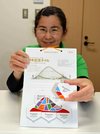開館５周年の記念タイル（手に持った物）。張り付けて飾ることができる「見本台紙」も作った＝多治見市笠原町、市モザイクタイルミュージアム