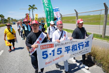　米軍嘉手納基地沿いを歩く「平和行進」の参加者＝１７日午後、沖縄県北谷町