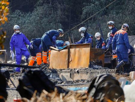　正琳寺の住居兼本堂などが全焼した現場を調べる警察官ら＝２１日午前１０時６分、山口県下関市