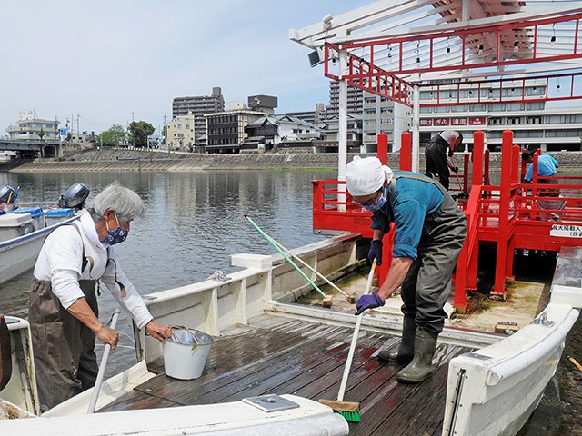 船の汚れを落とす船頭ら＝２２日午前１１時３分、岐阜市、長良川