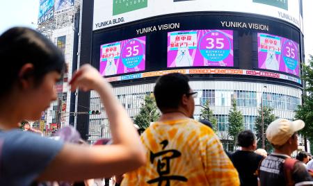 　熱中症警戒アラートが発表されていることを知らせる東京・新宿の大型ビジョン＝２２日午後