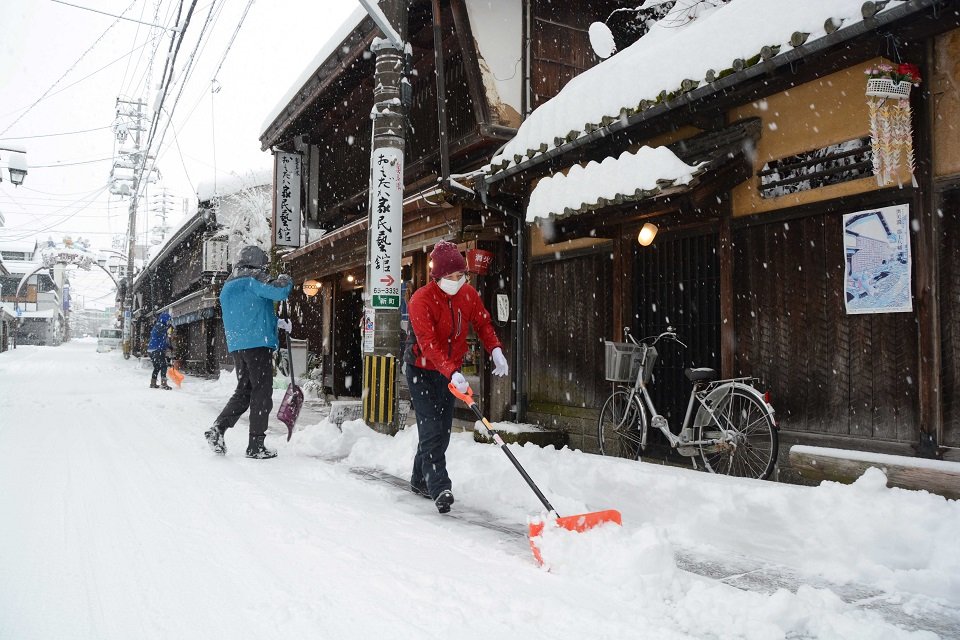 朝から雪かきに励む人たち＝２４日午前８時２８分、郡上市八幡町新町