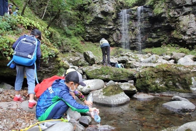長良川上流域の水を採取する児童ら＝郡上市高鷲町西洞、夫婦滝
