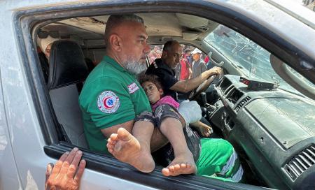 　パレスチナ自治区ガザ北部ガザ市で、イスラエル軍の空爆で負傷し搬送される子ども＝５日（ロイター＝共同）