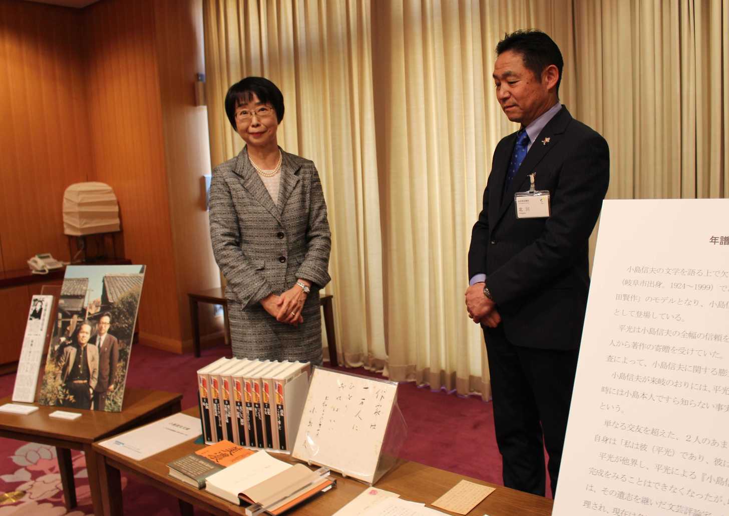 父・平光善久氏が収集した小島信夫氏の色紙や書籍、手紙について説明する原永子さん（左）＝岐阜市宇佐、県図書館