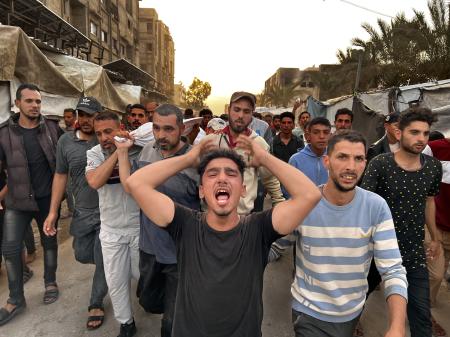 　１３日、パレスチナ自治区ガザ南部ハンユニスで、イスラエル軍の空爆を受けた病院の犠牲者を運ぶ人々（ゲッティ＝共同）
