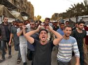 　１３日、パレスチナ自治区ガザ南部ハンユニスで、イスラエル軍の空爆を受けた病院の犠牲者を運ぶ人々（ゲッティ＝共同）