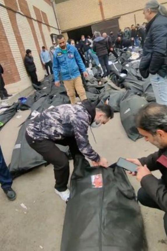 　イラン・テヘラン郊外で９〜１１日にかけて撮影された動画の中で、遺体の身元を確認する人々（ソーシャルメディアから、ＡＰ＝共同）