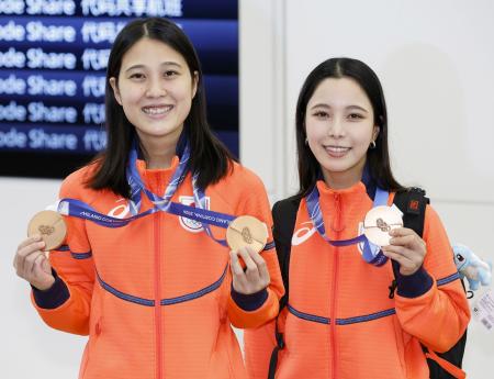 　羽田空港に到着しメダルを披露する、ノルディックスキージャンプ女子の丸山希（左）と高梨沙羅＝１８日午前