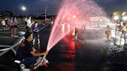 水を浴びて楽しむ子どもたち＝池田町六之井、町中央公民館南駐車場