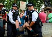 　抗議活動の参加者を排除する警察官＝９日、ロンドン（ゲッティ＝共同）