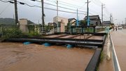 水路の水が道路にあふれ冠水。関係者らが対応に追われた＝１６日午後、関市下有知