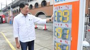 高い水準が続くガソリン価格を示す看板を見つめる和田隆社長＝２１日、岐阜市橋本町、ＥＮＥＯＳドクタードライブ岐阜駅前店