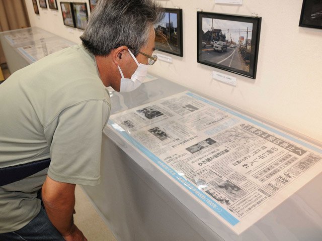 竹鼻線の出来事を伝える岐阜新聞の紙面を読む来館者＝羽島市竹鼻町、市歴史民俗資料館・映画資料館