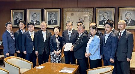 　地方議員の会のメンバーらから要望書を受け取る自民党の森山幹事長（左から６人目）＝６日午後、東京・永田町の党本部