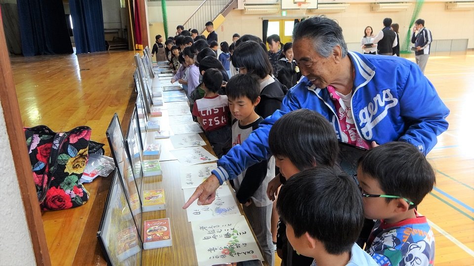 子どもたちにハワイの写真を見せる玉井宏光さん＝岐阜市安食、方県小学校