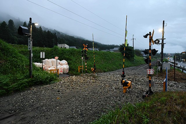 山側から土砂が流れ込み、線路が埋まったＪＲ高山線。国道４１号の崩落も含め、交通網の被害が観光に与える影響は計り知れない＝１１日午後７時１０分、下呂市萩原町上呂