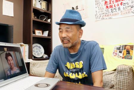 　袴田巌さんの姉ひで子さんから託された帽子をかぶり、ビデオ通話する前川彰司さん＝２１日午前、福井市（代表撮影）