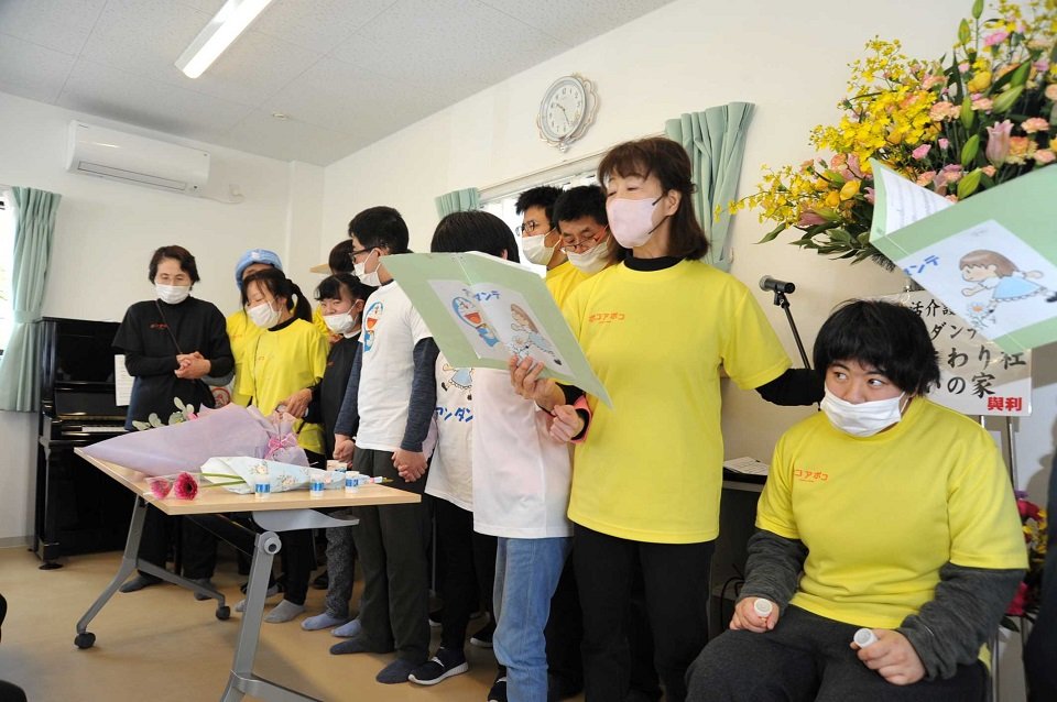 完成を祝い合唱を披露する利用者ら＝岐阜市三田洞東