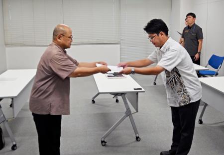 　防衛省沖縄防衛局の下幸蔵企画部長（右）に要請書を手渡す沖縄県の多良間一弘知事公室長＝３１日午後、沖縄県嘉手納町