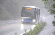 大きく水しぶきをあげながら進む路線バス＝２日午後０時４５分、中津川市福岡