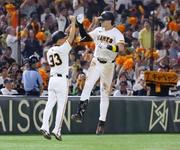 　８回、３ランを放ち、三塁コーチとタッチを交わす巨人・キャベッジ＝東京ドーム