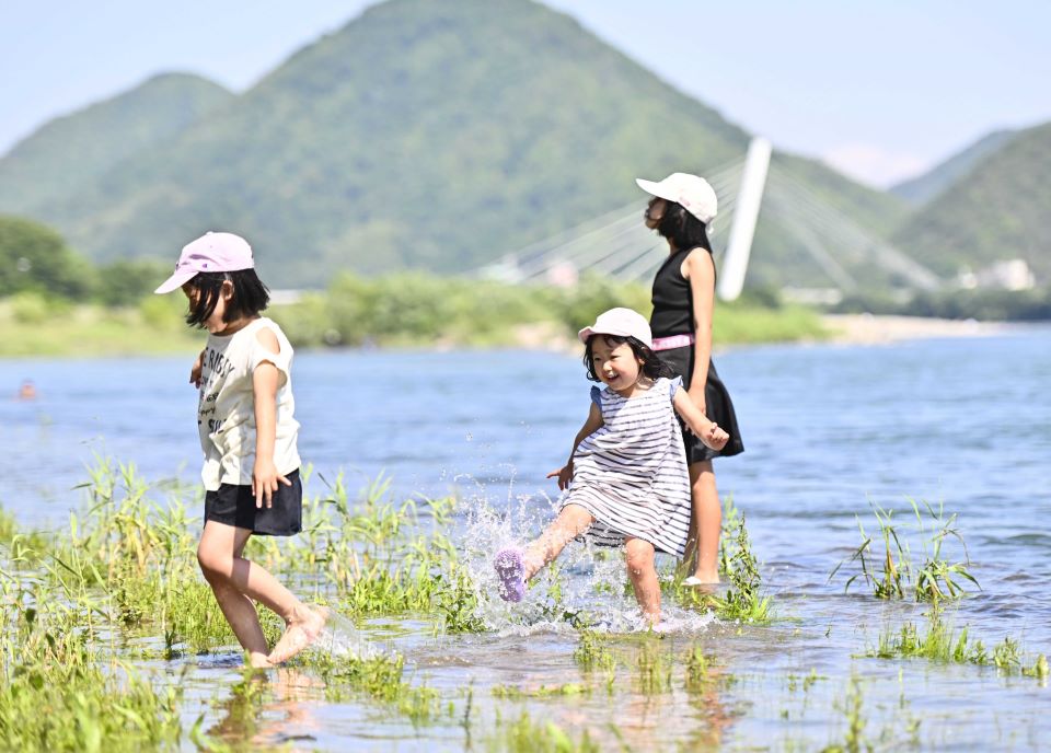 夏日の暑さの中、水遊びを楽しむ子どもたち＝２９日午後２時１４分、岐阜市の長良川