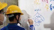 御望山トンネル工事現場で防水シートに絵を描く児童たち＝岐阜市御望