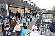 再開発地区とＪＲ多治見駅をつなぐ歩行者デッキを歩き初めする子どもたち＝多治見市本町