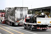 　事故があった新名神高速下り線の野登トンネルから運び出された焼けたトラックと車両（荷台上）＝２０日午後０時２３分、三重県菰野町