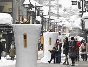 火がともされた雪像ろうそく＝１５日午後４時２３分、岐阜県飛騨市古川町