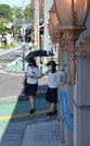 風鈴が飾られた通りを日傘や扇風機を手に歩く生徒ら＝２８日午後３時５５分、多治見市本町