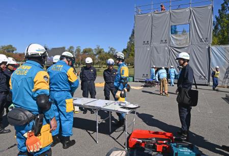 　建物の倒壊を想定した現場で訓練する警察官や消防隊員ら＝１８日午前、石川県小松市