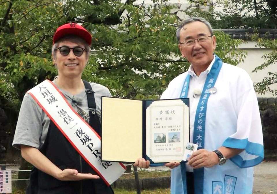 石田仁市長から委嘱状を受ける田村淳さん（左）＝大垣市郭町、大垣公園城西広場