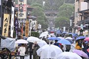 雨の参道を歩く観光客ら＝９日午前、岐阜県高山市、桜山八幡宮
