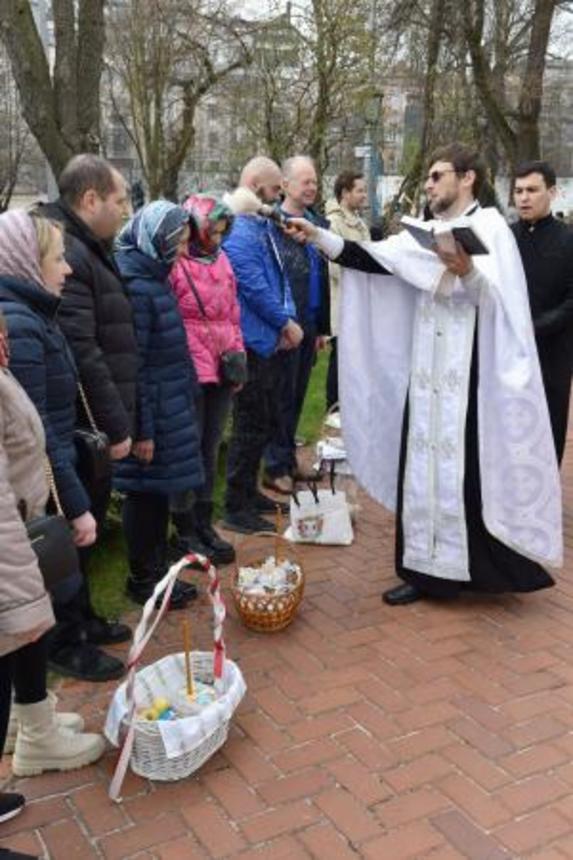 　キーウの聖ソフィア大聖堂で、市民に聖水をかける聖職者（右手前）＝１２日（共同）