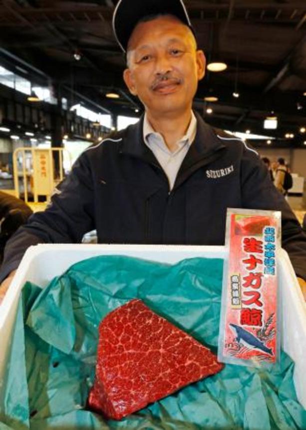 　最高値のナガスクジラの生肉と、競り落とした鈴力水産の山口清一社長＝３日午前、仙台市