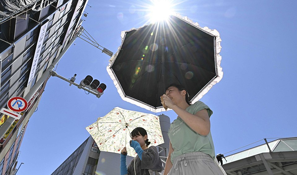 梅雨明けの好天の下、日傘を差して歩く女性たち＝２０日午前１１時１７分、岐阜市神田町