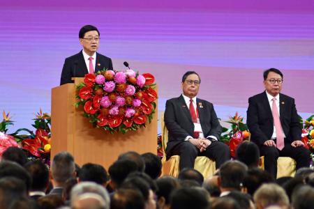 　返還２８年を祝う記念式典で演説する香港政府トップの李家超行政長官（左）＝１日、香港（共同）