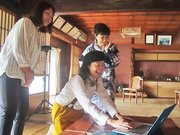 撮影した写真を確認する長尾明子さん（中央）。「この古民家で楽しいことをしたい」と話す＝加茂郡七宗町神渕