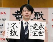 　竜王戦５連覇から一夜明け、色紙を手に写真に納まる藤井聡太竜王＝１４日午前、京都市下京区