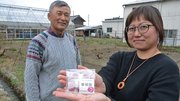 粉末にしたバラの花びらが練り込まれた飴を販売する窪田沙樹さん（右）と、父親でバラ苗農家の青木宏達さん＝同町古川、サンローズ