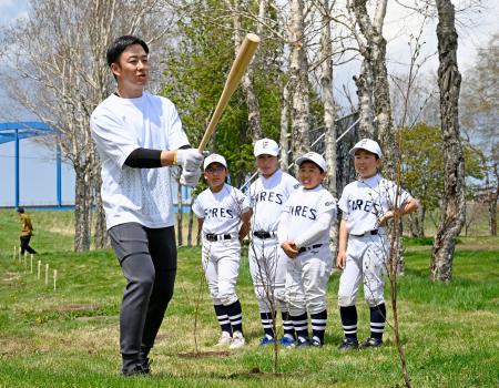 　バットの材料として期待される「ダケカンバ」の植樹を終えた斎藤佑樹さん（左端）＝５日午前、北海道長沼町